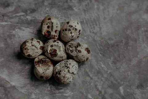 Cracked quail egg with broken shell on grey background Stock Photos