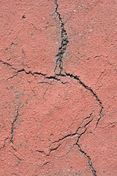 Cracked red asphalt ground texture in a vertical full frame background Stock Photos