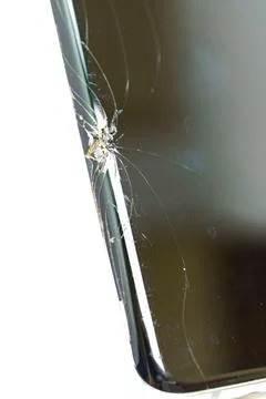 Cracked smartphone screen with spider web cracks near the edge Stock Photos