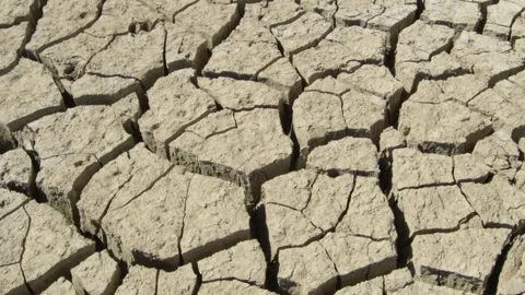 Cracked soil and dry river water sources lake drying cracked earth ecosystems Vídeo Stock 334030160