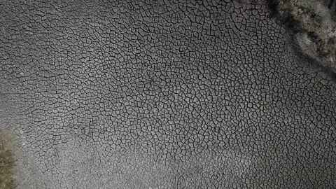 Cracked soil and dry river water sources lake drying cracked earth ecosystems Vídeo Stock 334030571