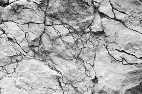 Cracked stone background. Close up of gray cracked mountain rock Stock Photos