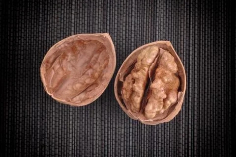 Cracked walnut on black background Stock Photos
