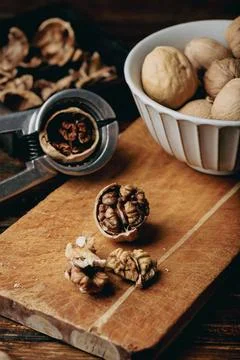 Cracked walnuts and nutcracker Stock Photos