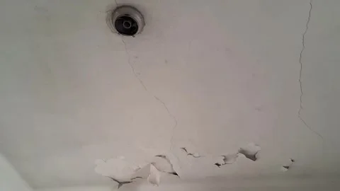 Cracked white ceiling showing water damage in motion video footage clip Stock Footage 339247436