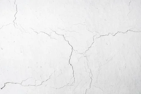 Cracked white wall with rough texture and visible lines Stock Photos