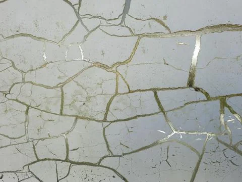 Cracked white wall surface with elegant metallic gold vein texture Stock Photos