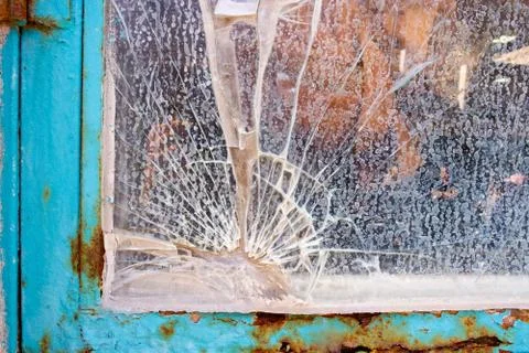 Cracked window in an old rusty frame Foto stock