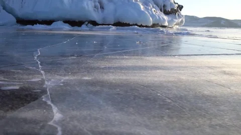 Cracked winter ice patterns during snowstorm frozen Lake Baikal Siberia Arctic  Stock Footage 317963673