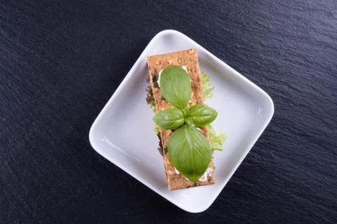 Cracker appetizer, basil on a white plate Stock Photos