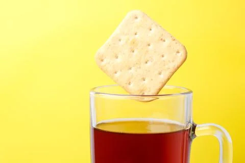 Cracker falling into a cup of tea Stock Photos