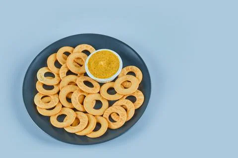 Cracker rings with a sauce on a ceramic plate Stock Photos