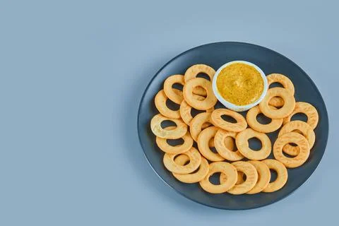 Cracker rings with a sauce on a ceramic plate Stock Photos