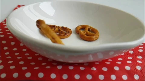 Cracker salted on a white background drops into a plate, slow-motion shot Stock Footage 87954143