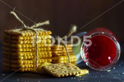 Crackers are tied with hemp rope and strawberry jam bottle. Stock Photos