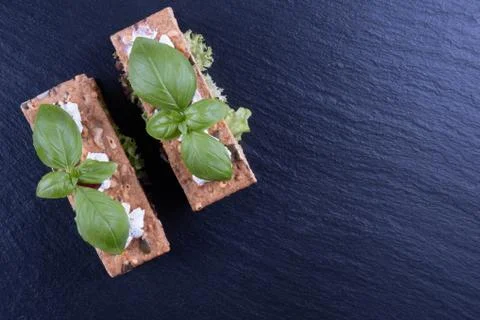 Crackers, basil on a black stone on a table Stock Photos