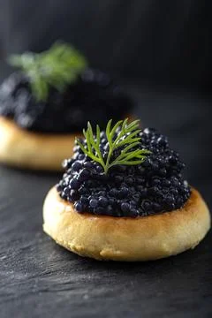 Crackers with black caviar Stock Photos