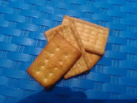 Crackers on blue woven surface. 스톡 사진