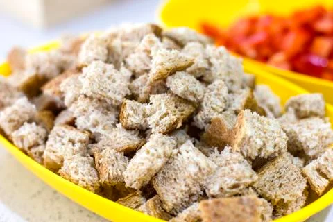 Crackers for Caesar salad. Pieces of bread in a yellow bowl Stock Photos
