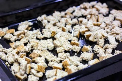 Crackers for Caesar salad. Pieces of bread on a baking tray for the oven Foto stock