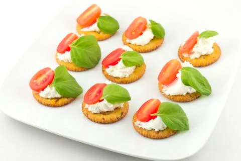 Crackers with cheese tomato and basil Stock Photos