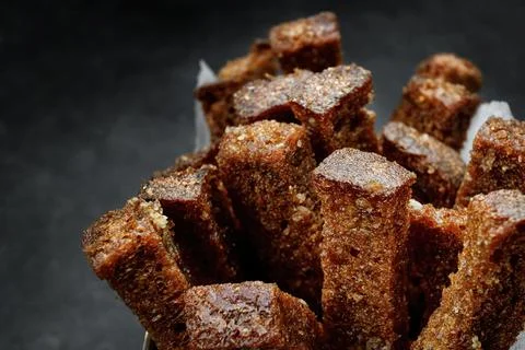 Crackers from dark bread with garlic, on a dark. Close up Stock Photos