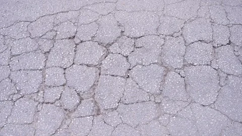 Cracking on asphalt surface. Crumbled street texture. Crocodile pattern Stock Footage 341776340