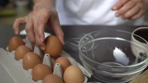 Cracking, breaking eggs into a mixing bowl. 動画素材 136491205