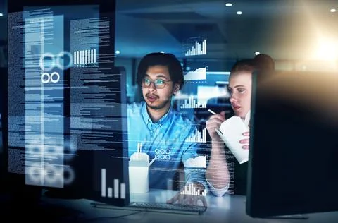 Cracking codes through the night. Shot of two focused young male programmers Stock-Fotos