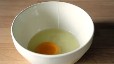 Cracking an egg into a bowl - slow motion Stock Footage 85567351