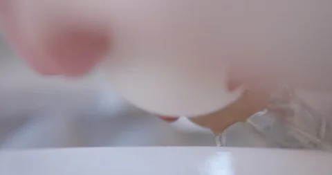 Cracking egg with falling yolk Stock-Footage 90272947