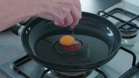 Cracking an egg into a frying pan. Stock Footage 337318905