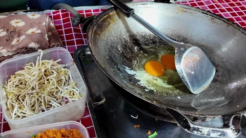 Cracking Egg into Hot Wok for Thai Street Food Cooking 4K Video stock 333189248