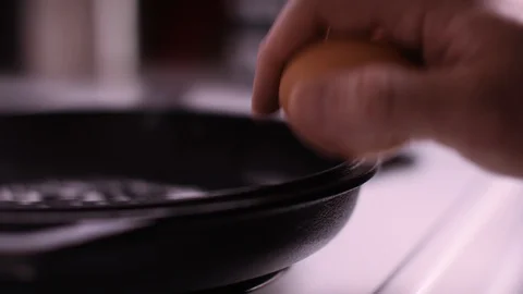 Cracking Egg on iron pan Stock Footage 128512124