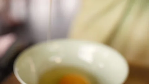 Cracking an Egg into Small Bowl, HD Stock Footage 148195433
