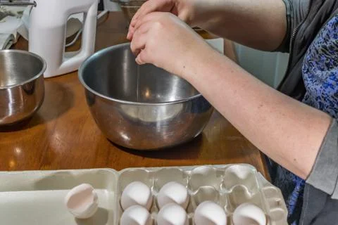 Cracking eggs into bowl Stock Photos