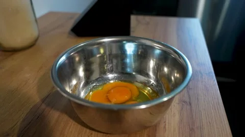 Cracking Eggs for Cooking and Preparing Delicious Dishes in a Kitchen Stock Footage 283486415