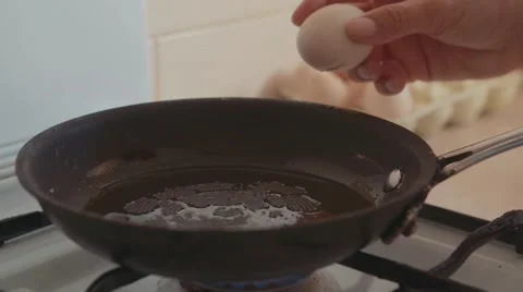 Cracking Eggs in to a hot pan Vidéo 68927993