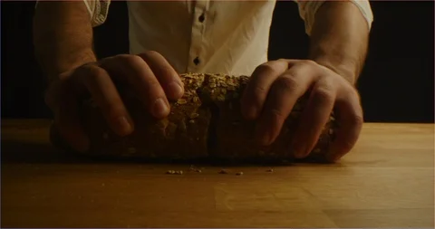 Cracking fresh brown bread with cereals into camera Stock Footage 126296038