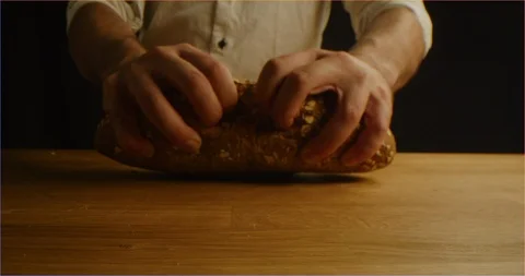 Cracking fresh brown bread with cereals into camera 库存影片 126296103