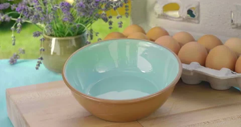 Cracking a fresh brown organic egg into a bowl Vídeo Stock 132932984