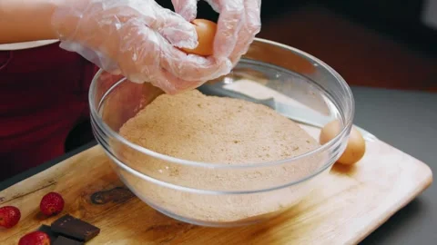 Cracking a fresh egg into a creamed butter mixture, 4K Stock Footage 341121326