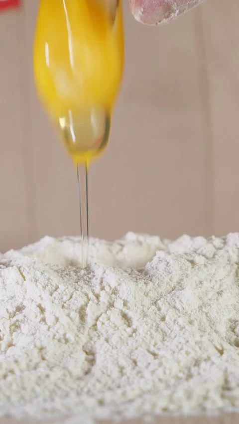 Cracking a fresh egg into flour for baking Stock Footage 341433102