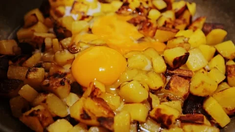 Cracking Fresh Egg Into Fried Potatoes Pan During Simple Home Cooking Process Stock Footage 325957685