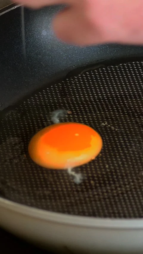 Cracking fresh egg into hot frying pan for breakfast cooking Stock Footage 343258777