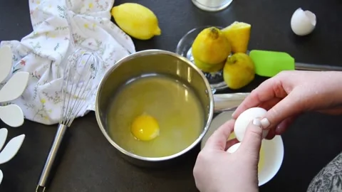 Cracking fresh eggs into saucepan for cooking 스톡 동영상 344661167