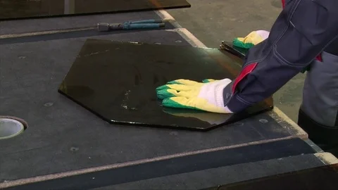 Cracking glass by worker hands on cutting table, window glass manufacturing Stock Footage 82402319