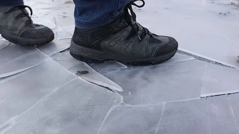 Cracking Ice Steps – Man in Winter Boots Walking on Fragile Frozen Ground Stock Footage 304490716