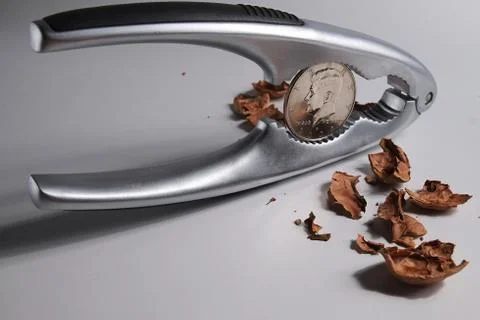 Cracking a nut to find a dollar inside Stock Photos