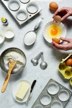 Cracking Open an Egg While Baking Muffins Stock Photos